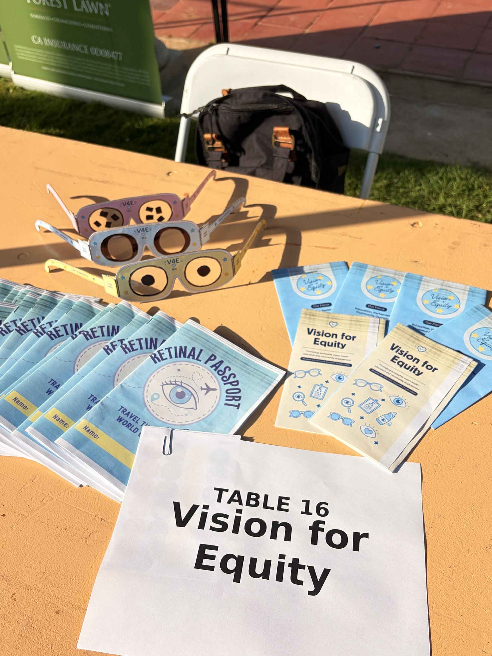 Retinal Passport booklets, educational glasses, and Vision for Equity handouts on the event table